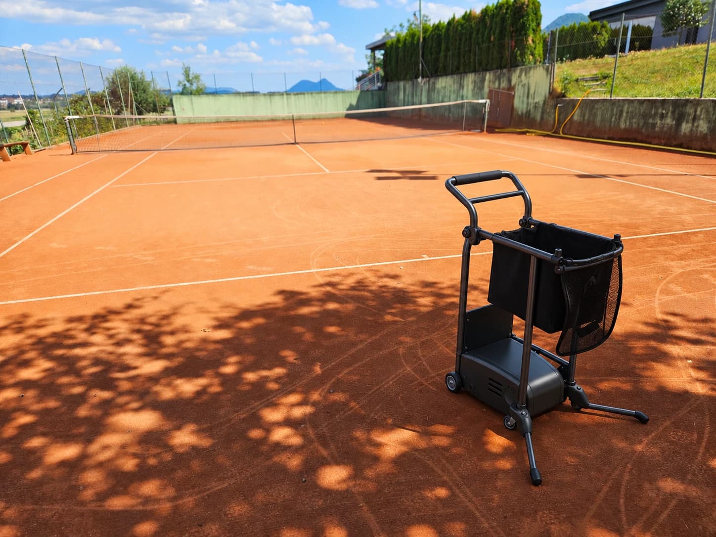 Melon Automation Tennis Machine on a clay tennis court